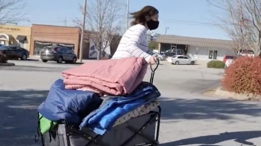 carrying a load of blankets for donation